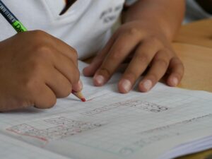 A child is sat a desk doing maths work